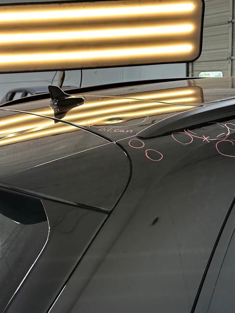Hail dents mapped on a black vehicle under a PDR light board
